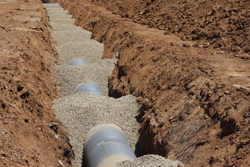 Drenáž ve štěrku s geotextilií – Česká Třebová, Dům ve svahu, drenáž z horní strany 24 bm, spád 0,8 %